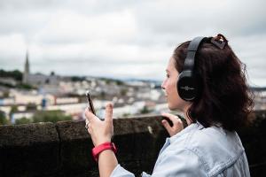 A woman wearing earphones at Derry's walls | NICRC