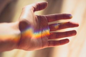 a rainbow prism of light on a hand | NICRC