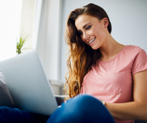 A smiling woman learning at a laptop | NICRC