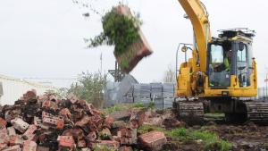 A diggers knocking down a brick wall | CRC NI