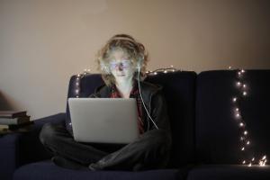 A teenager in the living room on a laptop | NICRC