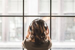 A woman listening on headphones | NI CRC