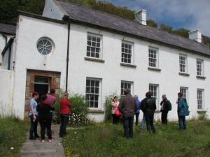 People gathered outside an old house | NICRC